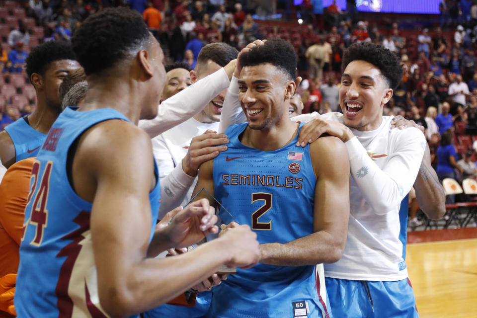 Florida State guard Anthony Polite (2) is mobbed by teammates after he received the MVP trophy after an NCAA college basketball game against South Florida, part of the Orange Bowl Classic tournament, Saturday, Dec. 21, 2019, in Sunrise, Fla. Florida State defeated South Florida 66-60. (AP Photo/Wilfredo Lee)