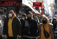 People wearing masks to help protect against the spread of coronavirus, walk in Ankara, Turkey, Friday, Nov. 27, 2020. When Turkey changed the way it reports daily COVID-19 infections, it confirmed what medical groups and opposition parties have long suspected — that the country is faced with an alarming surge of cases that is fast exhausting the Turkish health system. The official daily COVID-19 deaths have also steadily risen to record numbers in a reversal of fortune for the country that had been praised for managing to keep fatalities low. With the new data, the country jumped from being one of the least-affected countries in Europe to one of the worst-hit.(AP Photo/Burhan Ozbilici)
