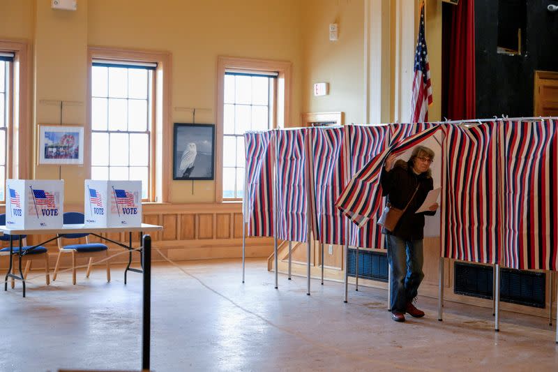 A voter enters a voting booth in New Hampshire's first-in-the-nation U.S. presidential primary election, in Gorham