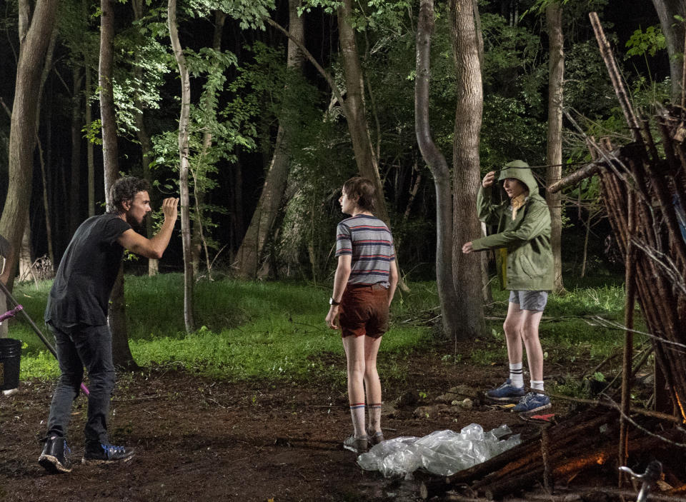 This image released by Netflix shows show creator Shawn Levy, left, with actors Noah Schnapp, center, and Finn Wolfhard on the Atlanta set of "Stranger Things." (Tina Rowden/Netflix via AP)