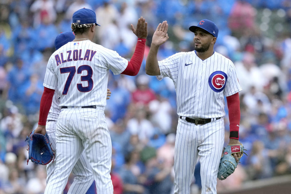 Chicago Cubs relief pitcher Adbert Alzolay (73) and Jeimer Candelario, celebrate after their win over the Atlanta Braves in a baseball game Saturday, Aug. 5, 2023, in Chicago. (AP Photo/Charles Rex Arbogast)