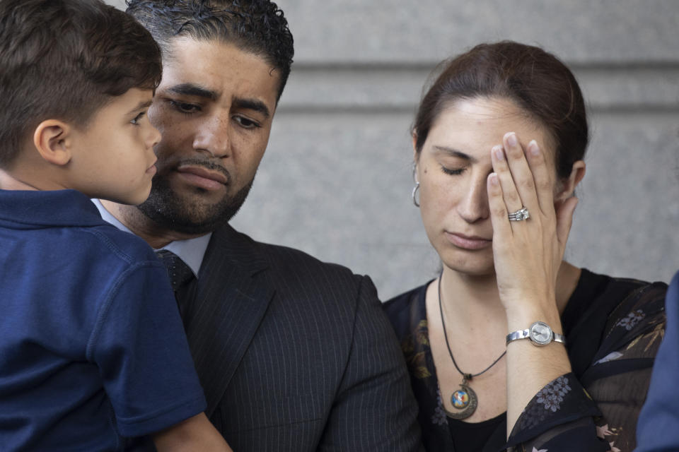 Juan Rodriguez, holding his son Tristan, leaves Bronx Criminal Court with his wife Marissa after a hearing, Thursday, Aug. 1, 2019 in New York. Rodriguez has pleaded not guilty to manslaughter and other charges in the deaths of their 1-year-old twins left in a car on Friday while he put in a day at work. Prosecutors say Rodriguez told police he thought he had dropped the twins off at day care.   (AP Photo/Mark Lennihan)