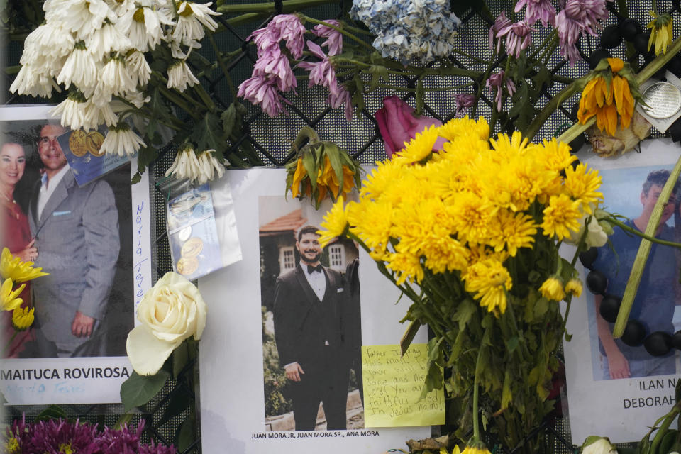 This June 29, 2021, photo shows a memorial wall for the victims of the Champlain Towers South building collapse in Surfside, Fla., with a photo of Juan Mora Jr. (AP Photo/Gerald Herbert)