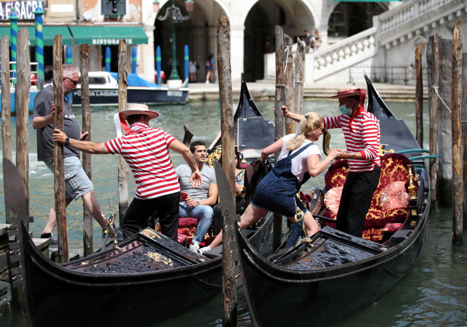 Gondoliers help tourists to get on the gondolas, as the region of Veneto becomes a 