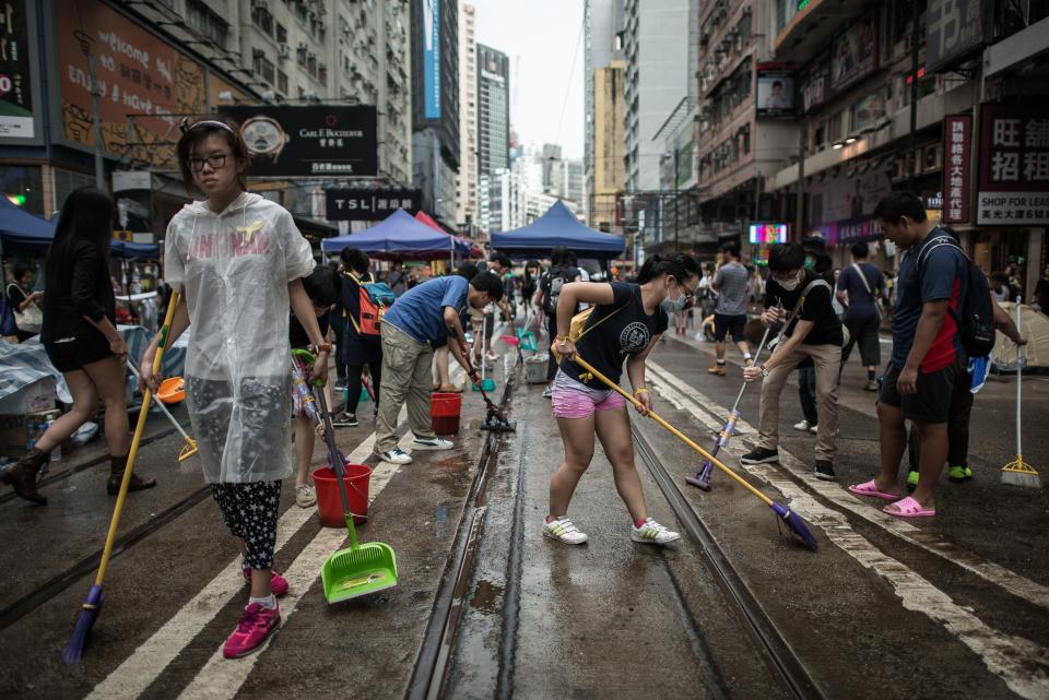 Pro-democracy demonstrators clean an occupied area of Hong Kong on October 3, 2014. (PHILIPPE LOPEZ/AFP/Getty Images)