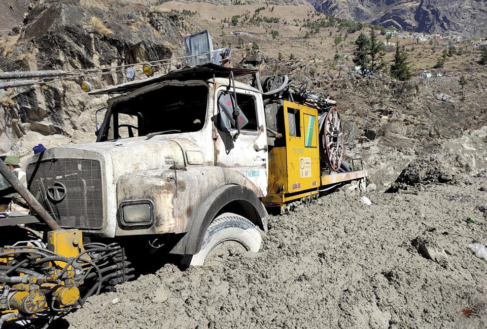 A hydro project vehicle is seen stuck in slash and mud at Reni village in the Tapovan area of ​​Chamoli district, in Indian state of Uttrakhund, Monday, Feb.8, 2021. Rescuers were working Monday to rescue more than three dozen power plant workers trapped in a tunnel after part of a Himalayan glacier broke off Sunday and sent a wall of water and debris rushing down the mountain. (AP Photo)