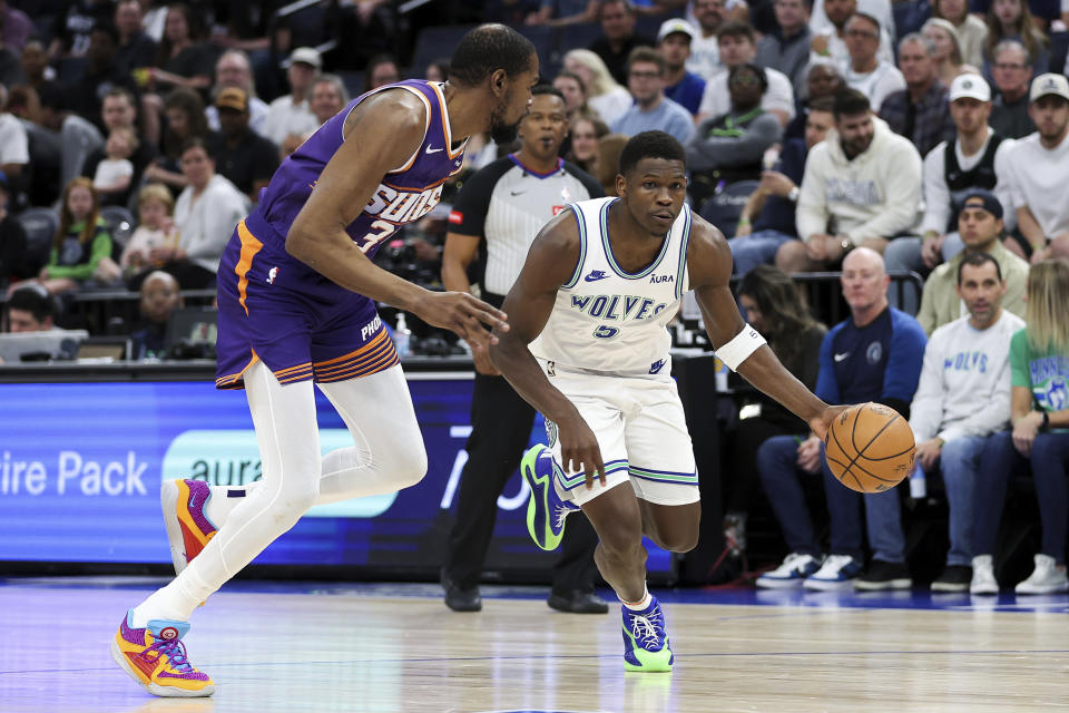 Minnesota Timberwolves guard Anthony Edwards, right, works toward the basket as Phoenix Suns forward Kevin Durant (35) defends during the first half of an NBA basketball game Sunday, April 14, 2024, in Minneapolis. (AP Photo/Matt Krohn)