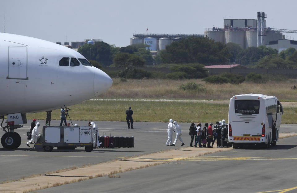 Passengers disembark from a plane on their arrival in Polokwani, South Africa, Saturday, March 14, 2020 after being repatriated from Wuhan, China where they will be kept in quarantine at a nearby resort. For most people the new coronavirus causes only mild or moderate symptoms, such as fever and cough. For some, especially older adults and people with existing health problems, it can cause more severe illness, including pneumonia. (AP Photo)