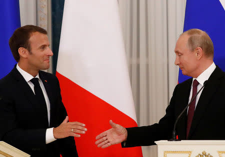 Russian President Vladimir Putin (R) and his French counterpart Emmanuel Macron shake hands as they leave after a news conference in St. Petersburg, Russia May 24, 2018. REUTERS/Grigory Dukor