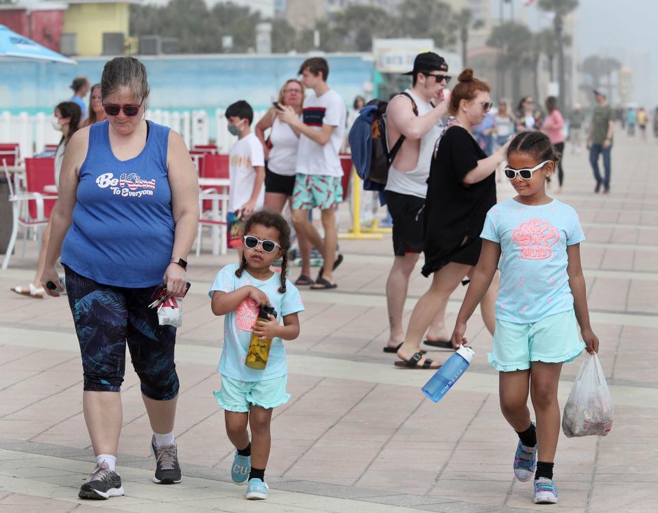 Families and young adults pack the boardwalk on March 23, 2021, as spring break takes a more family turn in Daytona Beach, Fla.