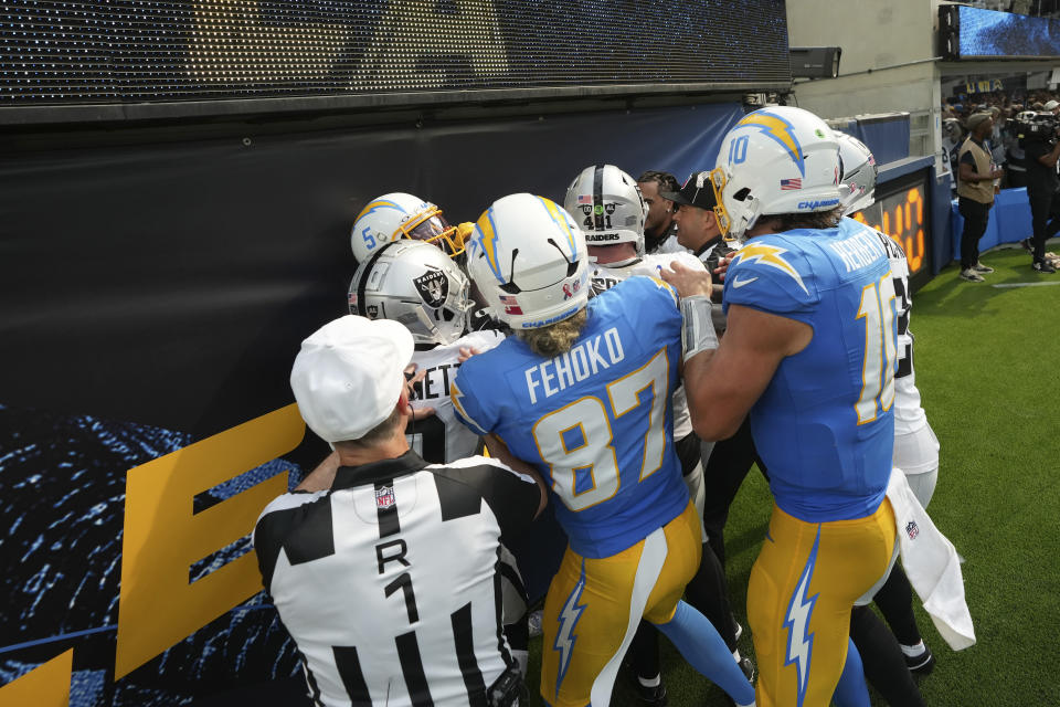 Petugas mencoba memisahkan pemain dari Los Angeles Chargers dan Las Vegas Raiders selama babak kedua pertandingan sepak bola NFL, Minggu, 8 September 2024, di Inglewood, California. (Foto AP/Marcio Jose Sanchez)