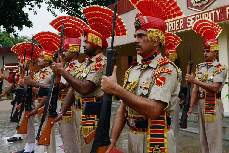 Indian Border Security Force soldiers present arms during a flag hoisting ceremony to celebrate India's Independence Day at the India-Pakistan Wagah border post on August 15, 2013