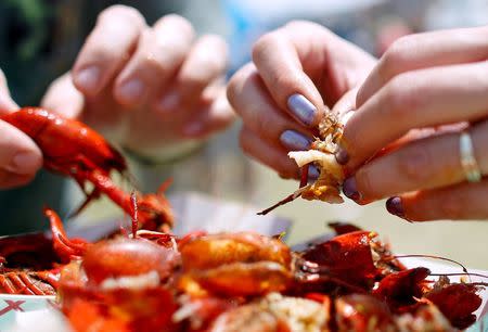 Festival goers eat crawfish during the first day of the New Orleans Jazz and Heritage Festival in New Orleans, Louisiana, in this April 25, 2014, file photo. REUTERS/Jonathan Bachman/Files