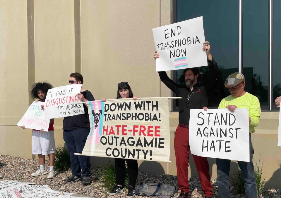 Local activists stand outside the Outagamie County Government Center on Tuesday to protest transphobic comments made by county board member Timothy Hermes.