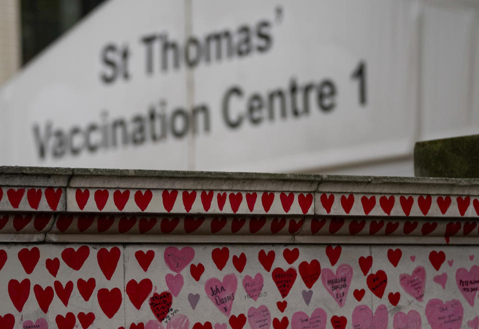 The vaccination center of St Thomas' Hospital sits behind the National Covid Memorial Wall in London, Tuesday Nov. 9, 2021. The British government is due to decide about mandatory vaccination for NHS staff.(AP Photo/Frank Augstein)