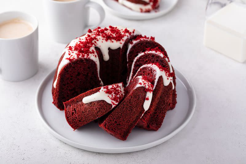 Red velvet bundt cake with cream cheese frosting and cake crumbs