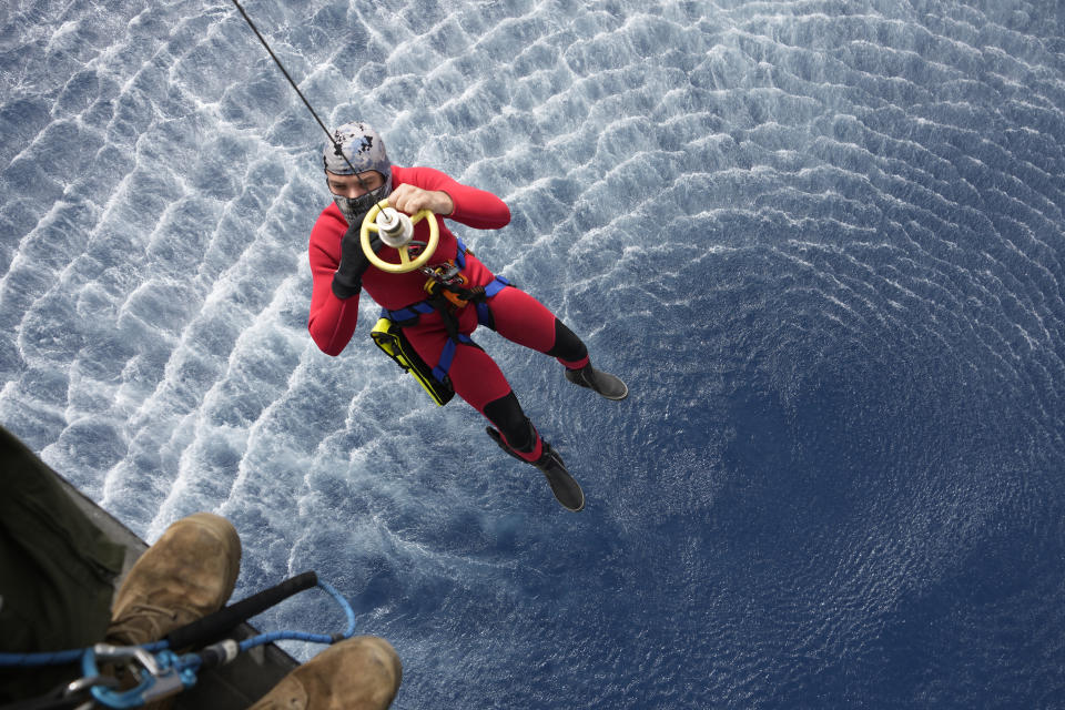 FILE - A Lebanese navy rescuer is lowered on rope from a helicopter as the search for bodies continues following the sinking over last week of a boat packed with migrants as the Lebanese navy tried to force it back to shore, in Tripoli, north Lebanon, Monday, April 25, 2022. A week ago, a boat carrying around 60 Lebanese trying to escape their country and reach Europe sank in the Mediterranean after colliding with a Navy ship. At least seven people are known dead and at least six are missing. The tragedy underscored the desperation among many Lebanese after the collapse of their country's economy. (AP Photo/Hassan Ammar, File) around