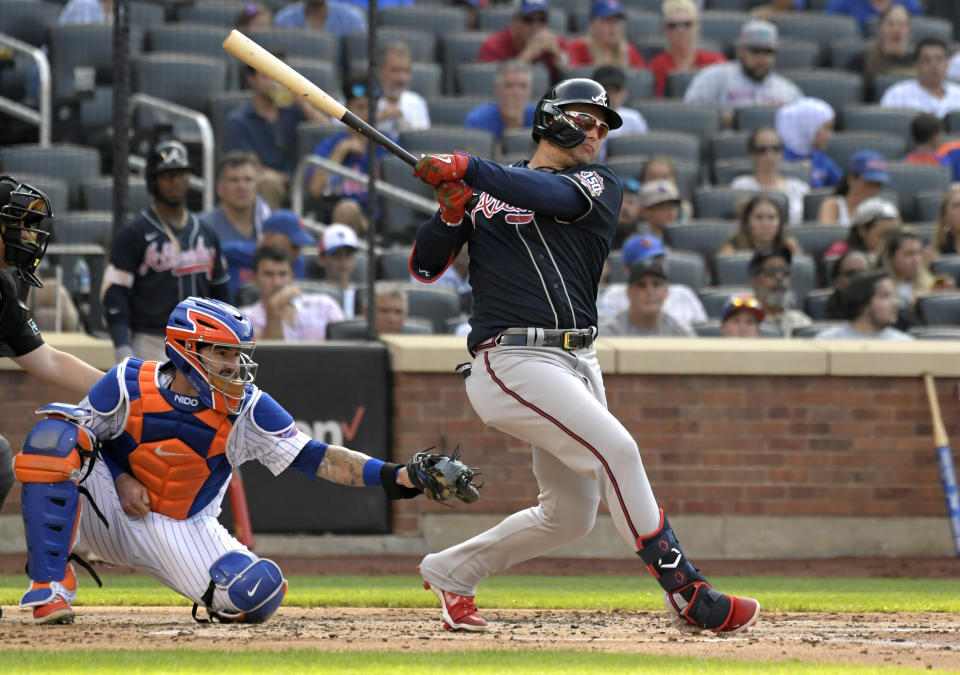 Atlanta Braves' Joc Pederson, right, hits an RBI-double, scoring Guillermo Heredia, as New York Mets catcher Tomas Nido, second from right, looks on during the third inning of the first game of a baseball doubleheader Monday, July 26, 2021, in New York. (AP Photo/Bill Kostroun)