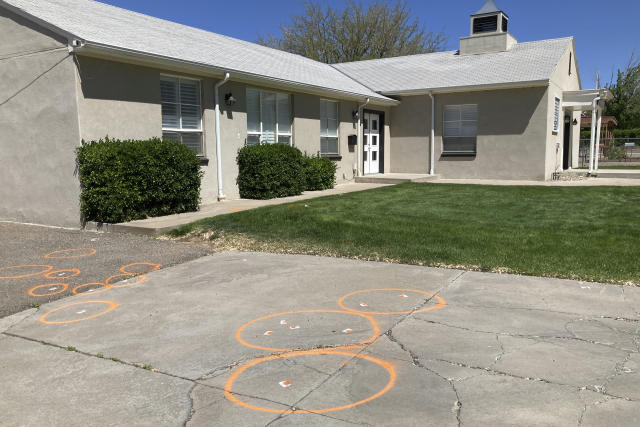 Painted circles mark locations where evidence related to a deadly shooting was collected in front of a church in Farmington, New Mexico on Tuesday, May 16, 2023. Authorities killed the 18-year-old gunman Monday and the investigation is ongoing. (AP Photo/Susan Montoya Bryan)