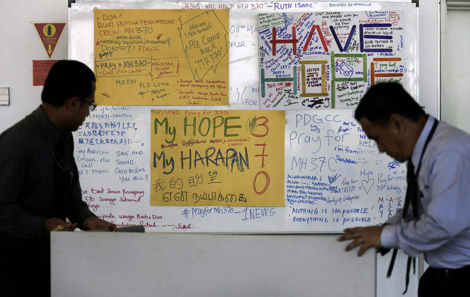 Airport staff move a white board plastered with messages of hope and encouragement to all involved with the missing Malaysia Airlines jet, MH370, at the Kuala Lumpur International Airport, Tuesday, March 11, 2014, in Sepang, Malaysia. Authorities hunting for the missing Malaysia Airlines jetliner expanded their search on land and sea Tuesday, reflecting the difficulties in locating traces of the plane more than three days after it vanished. (AP Photo/Wong Maye-E)