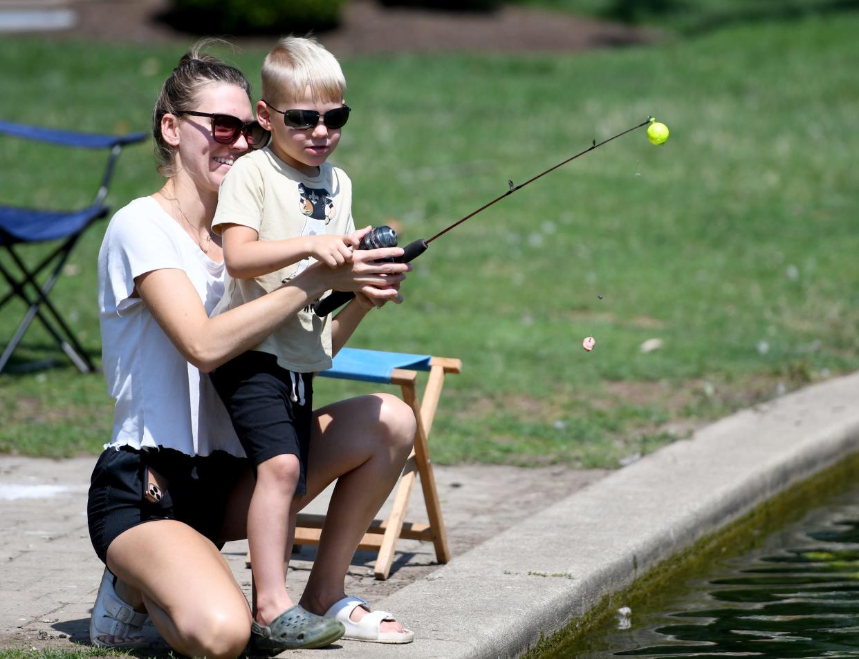 Cullen Allen, 5, of Jackson Township gets help from his mother Ashton Allen while fishing at Price Park in North Canton.