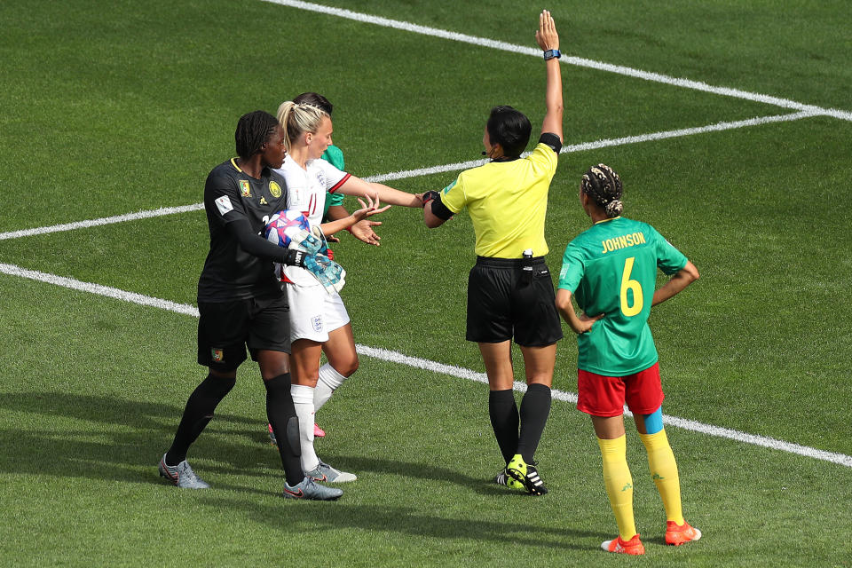 VALENCIENNES, FRANCE - JUNE 23: Toni Duggan of England shows referee Qin Liang phlegm on her arm after she is spat on by Augustine Ejangue of Cameroon (behind) during the 2019 FIFA Women's World Cup France Round Of 16 match between England and Cameroon at Stade du Hainaut on June 23, 2019 in Valenciennes, France. (Photo by Charlotte Wilson/Offside/Offside via Getty Images)