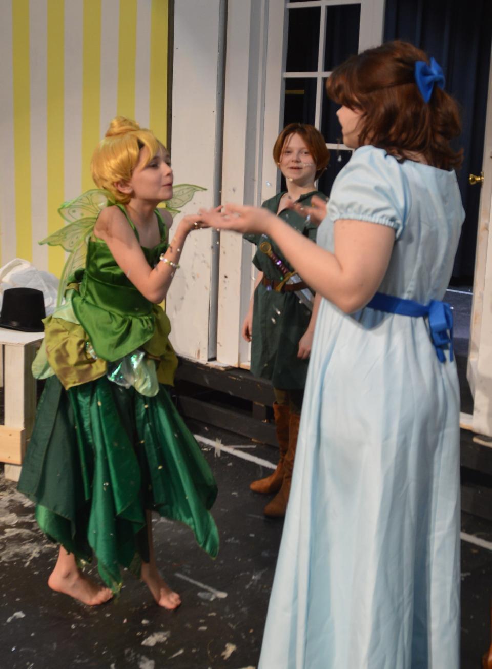 Tinkerbell gives Wendy her share of pixie dust.