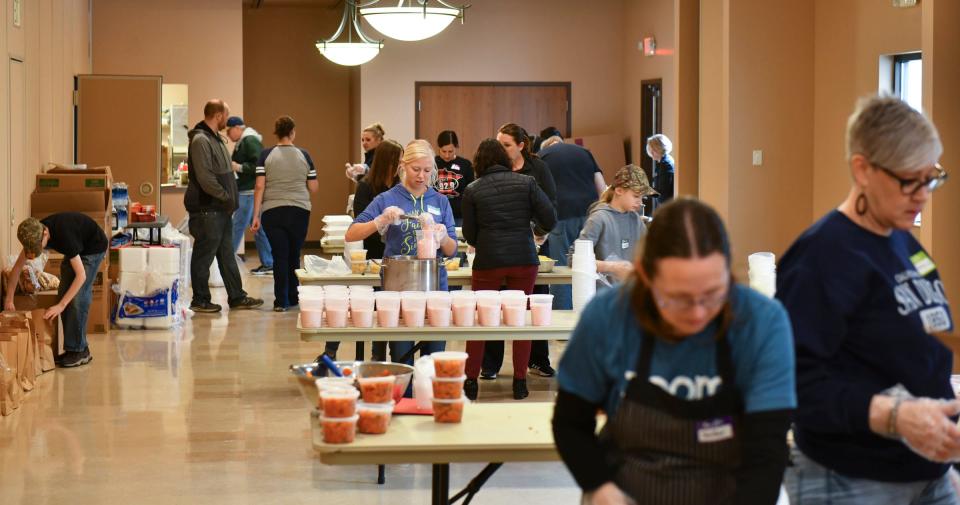 Volunteers work to prepare items for hundreds of easter meals Thursday, April 14, 2022, in the kitchen area of Heritage Hall at the Church of St. Joseph. 