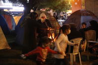 Children play as ocal residents living in tents outdoors try to stay warm in Izmir, Turkey, Monday, Nov. 2, 2020. In scenes that captured Turkey's emotional roller-coaster after a deadly earthquake, rescue workers dug two girls out alive Monday from the rubble of collapsed apartment buildings three days after the region was jolted by quake that killed scores of people. Close to a thousand people were injured. (AP Photo/Darko Bandic)