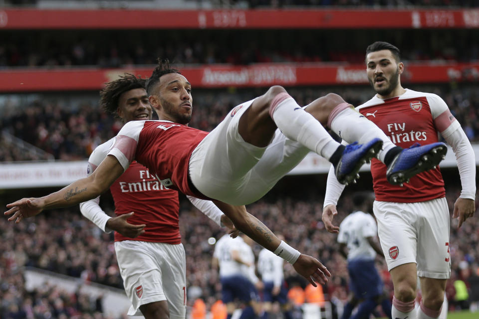 Arsenal's Pierre-Emerick Aubameyang celebrates with his teammates after scoring his side's opening goal from the penalty spot during the English Premier League soccer match between Arsenal and Tottenham Hotspur at the Emirates Stadium in London, Sunday Dec. 2, 2018. (AP Photo/Tim Ireland)