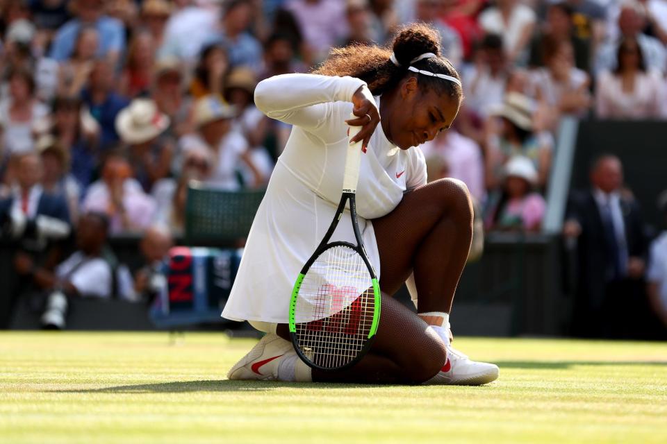 A frustrated Serena Williams kneels on the court after losing a point during the 2018 Wimbledon final.