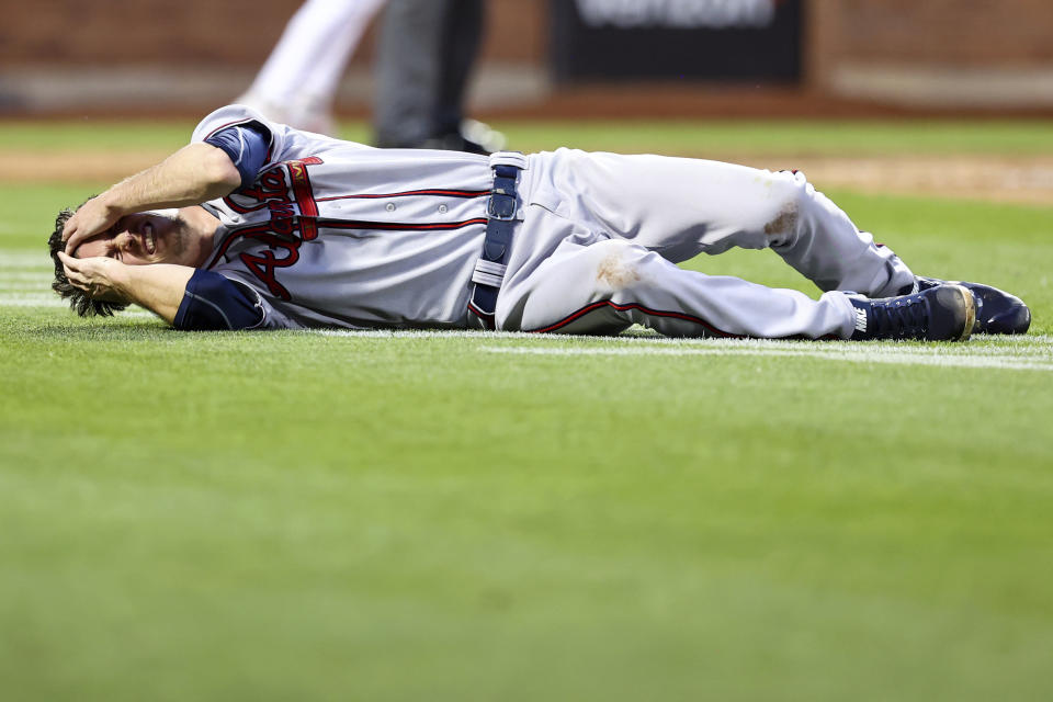 Atlanta Braves starting pitcher Max Fried lies on the ground after New York Mets' Francisco Lindor and Starling Marte scored during the third inning of the second game of a baseball doubleheader on Saturday, Aug. 6, 2022, in New York. (AP Photo/Jessie Alcheh)