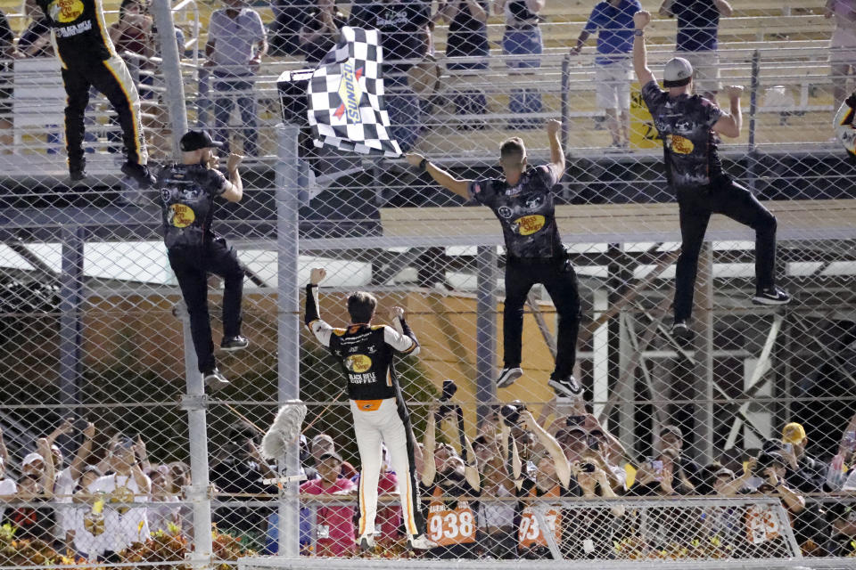 Noah Gragson, second from left, climbs the wall with his crew after winning the NASCAR Xfinity Series auto race at Homestead-Miami Speedway, Saturday, Oct. 22, 2022, in Homestead, Fla. (AP Photo/Terry Renna)