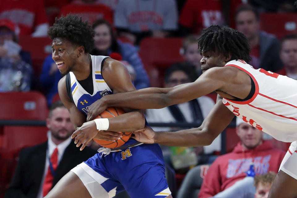 McNeese State guard Harwin Francois, left, tries to protect the ball as Houston forward Jarace Walker, right, reaches for it during the first half of an NCAA college basketball game Wednesday, Dec. 21, 2022, in Houston. (AP Photo/Michael Wyke)