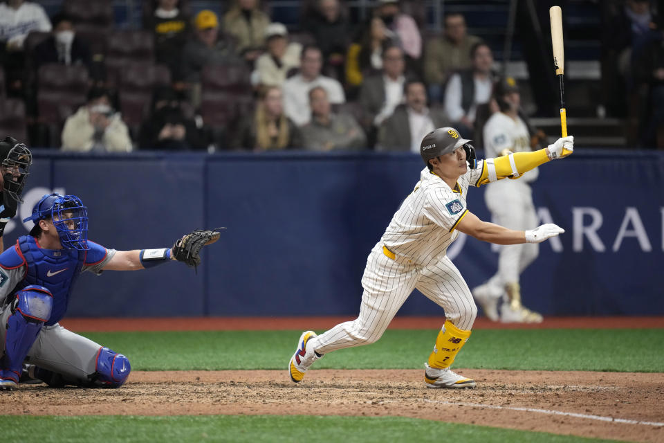San Diego Padres' Ha-Seong Kim, right, flies out as Los Angeles Dodgers catcher Will Smith watches during the ninth inning of an opening day baseball game at the Gocheok Sky Dome in Seoul, South Korea Wednesday, March 20, 2024, in Seoul, South Korea. (AP Photo/Lee Jin-man)
