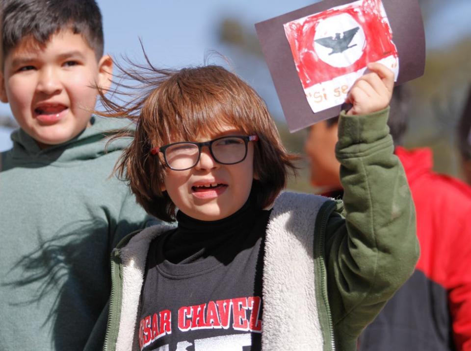 Students from La Fe Preparatory School march through the Segundo Barrio in celebration of César Chávez Day on Friday. Students waved United Farm Workers flags and chanted, “Si se puede.”