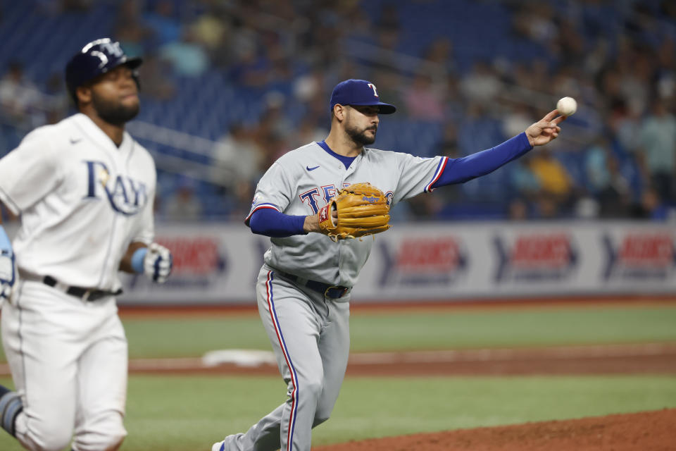 Texas Rangers starting pitcher Martin Perez throws to first for the out on a bunt by Tampa Bay Rays' Manuel Margot, left, during the fifth inning of a baseball game Friday, Sept. 16, 2022, in St. Petersburg, Fla. (AP Photo/Scott Audette)