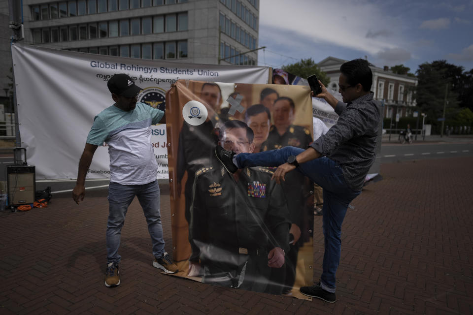 A pro-Rohingya demonstrator kicks an image senior general Min Aung Hlaing, Myanmar military governor, outside the International Court of Justice in The Hague, Netherlands, Friday, July 22, 2022, where judges rule on whether a case brought by Gambia alleging that Myanmar is committing genocide against the Rohingya can go ahead. Myanmar argues that the court does not have jurisdiction. (AP Photo/Peter Dejong)