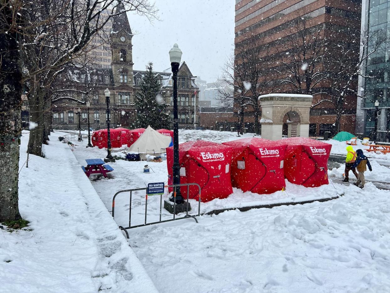 Ice-fishing shelters over tents are shown at Halifax's city hall earlier this month. They were purchased by volunteer groups to help keep tents drier during heavy precipitation. (Paul Palmeter/CBC - image credit)