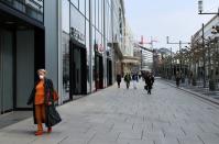 FILE PHOTO: A woman wearing a protective mask walks downtown in Frankfurt, Germany, in March 2020