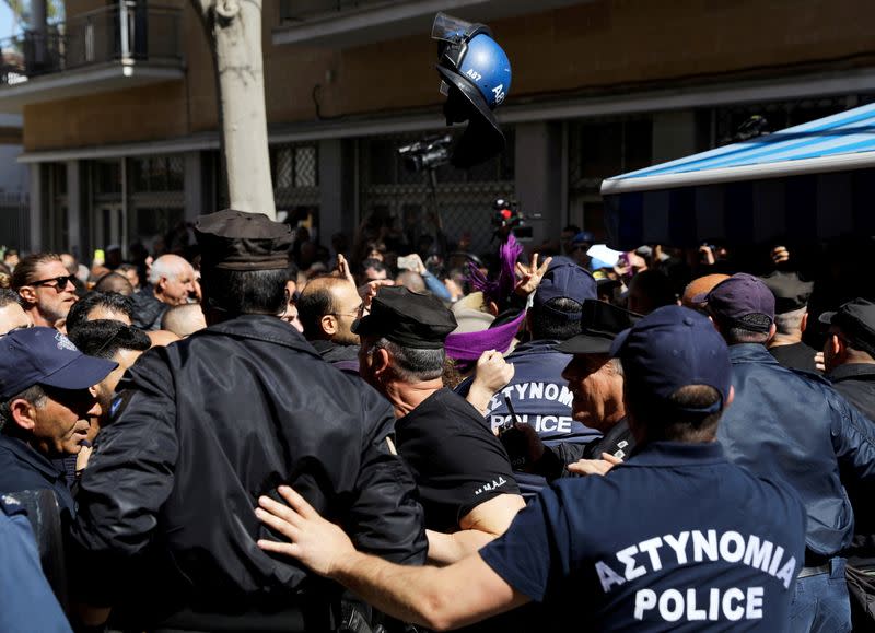 Turkish Cypriots scuffle with Greek Cypriot policemen at Ledra's checkpoint of the U.N.-controlled buffer zone, after authorities declared the crossing temporarily shut to curb any potential spread of coronavirus,