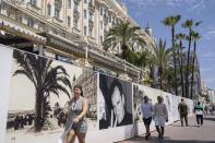 People walk along the Croisette prior to the 75th international film festival, Cannes, southern France, Monday, May 16, 2022.The Cannes film festival runs from May 17th until May 28th 2022. (AP Photo/Petros Giannakouris)
