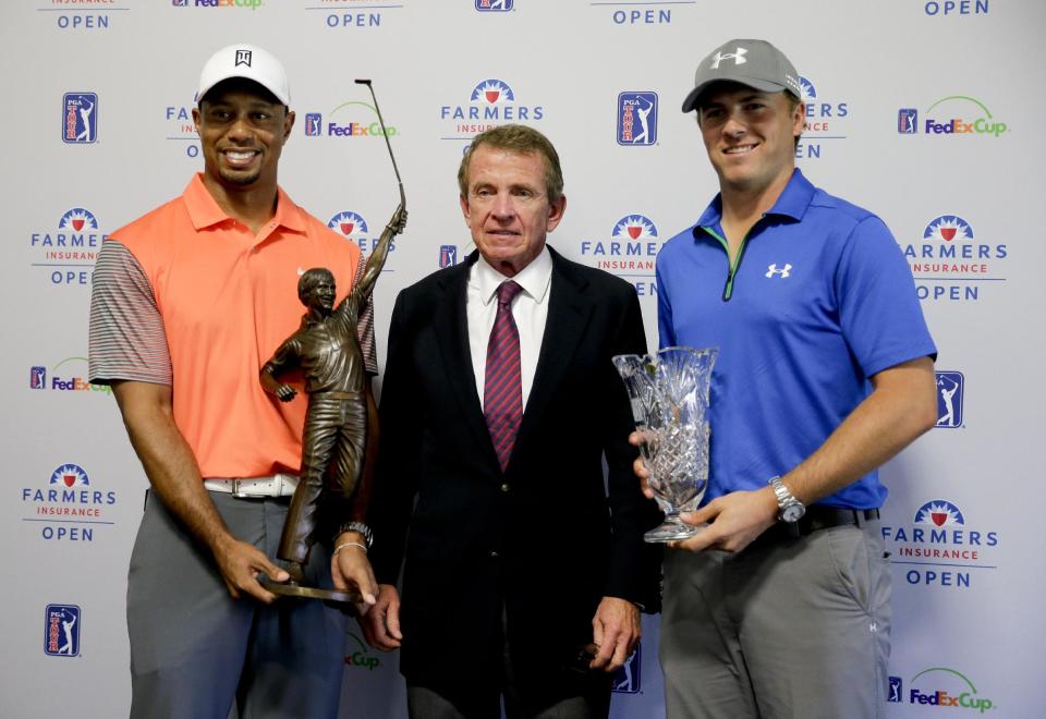 Tiger Woods, left, 2013 PGA Tour Player of the Year, and Jordan Spieth, right, PGA Tour Rookie of the Year, pose with PGA Tour Commissioner Tim Finchem and their trophies during a presentation at the Farmers Insurance Open golf tournament at Torrey Pines Golf Course on Wednesday, Jan. 22, 2014 in San Diego. (AP Photo/Chris Carlson)