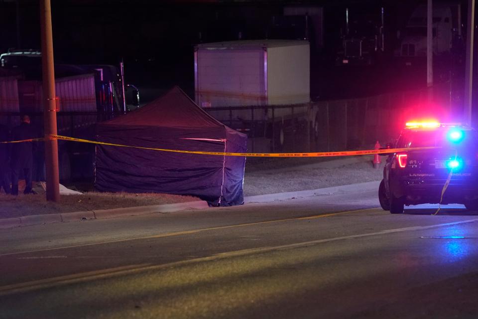 A tent covers the body of a gunman, Tuesday, Feb. 14, 2023, in Lansing, Mich., who opened fire Monday night at Michigan State University, killing three people and wounding five more, before fatally shooting himself miles away after an hours-long manhunt that forced frightened students to hide in the dark.