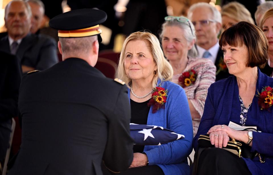 President M. Russell Ballard’s daughter, Holly Clayton, is presented with the American flag and another daughter, Stacey Murdock, looks on at the graveside service for President Ballard in the Salt Lake City Cemetery on Friday, Nov. 17, 2023. | Scott G Winterton, Deseret News