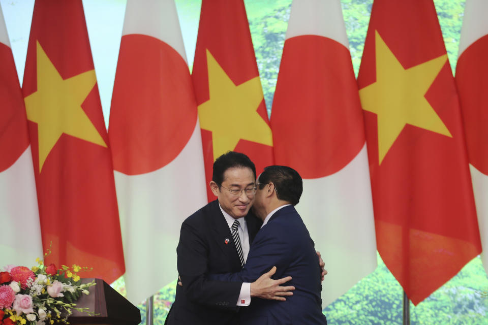 Japanese Prime Minister Fumio Kishida, left, and Vietnamese Prime Minister Pham Minh Chinh hug in Hanoi, Vietnam on Sunday, May 1, 2022. (AP Photo/Hoang Minh)