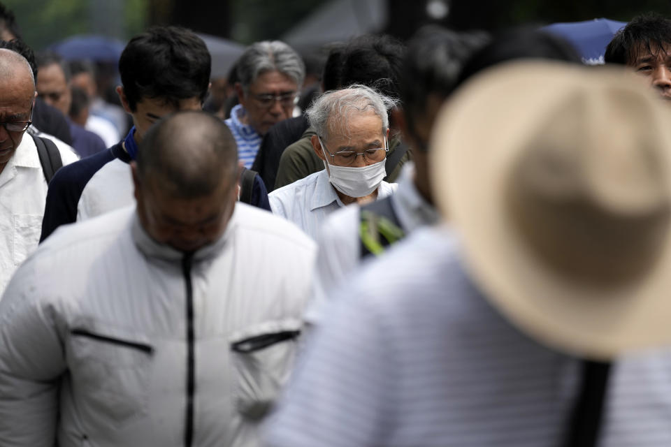 Visitors observe a minute of silence at noon at the Yasukuni Shrine, which honors Japan's war dead, including convicted war criminals, Tuesday, Aug. 15, 2023, in Tokyo. Japan holds annual memorial service for the war dead as the country marks the 78th anniversary of its defeat in the World War II. (AP Photo/Eugene Hoshiko)