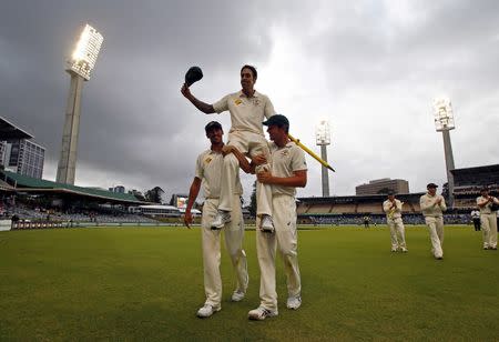 Australia's Mitchell Johnson (C) reacts as he is carried from the field by team mates Mitchell Starc (L) and Josh Hazlewood at the end the fifth day of the second cricket test match against New Zealand at the WACA ground in Perth, Western Australia, November 17, 2015. REUTERS/David Gray