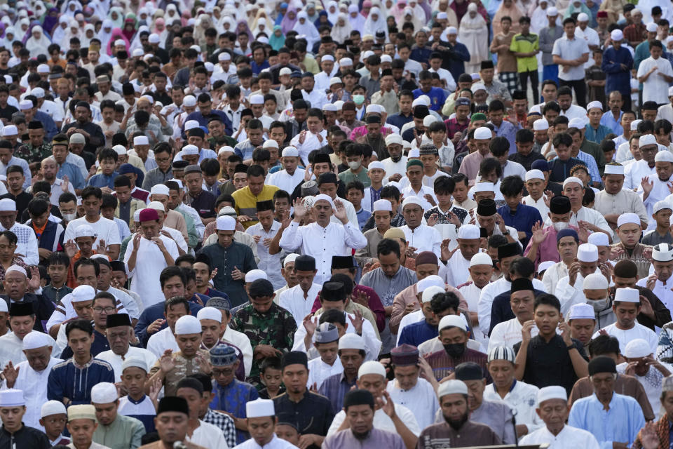 Muslims perform a morning prayer marking the Eid al-Adha holiday on a street in Jakarta, Indonesia, Thursday, June 29, 2023. Muslims around the world will celebrate Eid al-Adha, or the Feast of the Sacrifice, slaughtering sheep, goats, cows and camels to commemorate Prophet Abraham's readiness to sacrifice his son Ismail on God's command. (AP Photo/Tatan Syuflana)