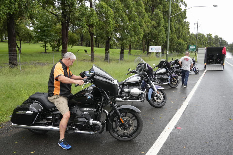 Paul Swinfield prepares to load his BMW motorbikes into a truck as he escapes the floods on the outskirts of Sydney, Australia, Thursday, March 3, 2022.Tens of thousands of people had been ordered to evacuate their homes and many more had been told to prepare to flee as parts of Australia's southeast coast are inundated by the worst flooding in decades. (AP Photo/Rick Rycroft)